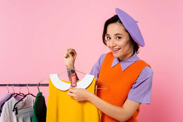 Mulher feliz mostrando etiqueta venda no vestido sem mangas amarelo isolado em rosa — Fotografia de Stock