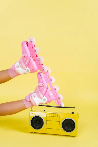 Partial view of african american woman on roller skates near retro boombox on yellow — Stock Photo