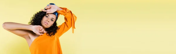 Young african american woman in headscarf posing while look at camera isolated on yellow, banner — Stock Photo