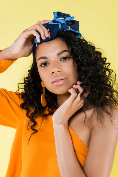 Pretty african american woman in kerchief looking at camera isolated on yellow — Stock Photo