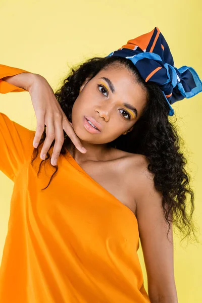 African american woman with bare shoulder posing isolated on yellow — Stock Photo