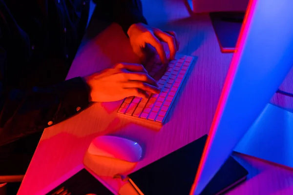 Cropped view of programmer using computer near notebook on table — Stock Photo