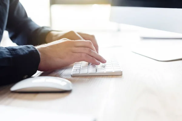 Vue recadrée du programmeur à l'aide du clavier d'ordinateur dans le bureau — Photo de stock