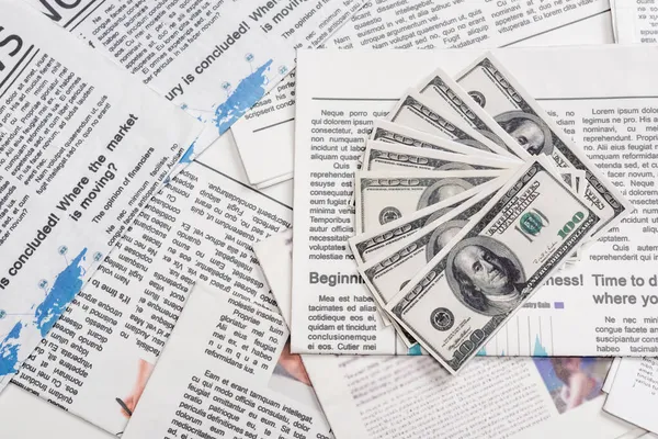 KYIV, UKRAINE - NOVEMBER 1, 2021: top view of dollar banknotes on printed newspapers — Stock Photo