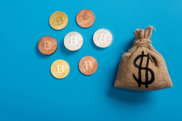 Top view of canvas money bag near bitcoins on blue — Stock Photo