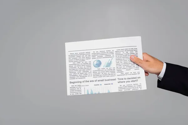 Обрізаний вид людини, що тримає газету ізольовано на сірому — стокове фото