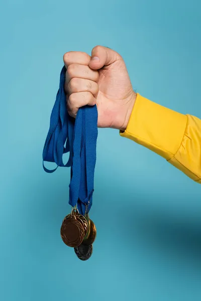 Обрезанный вид чемпиона с медалями на синем — стоковое фото