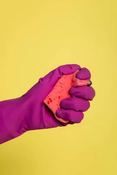 Vista parziale dell'uomo in guanto di gomma rosa con spugna isolata sul giallo — Foto stock