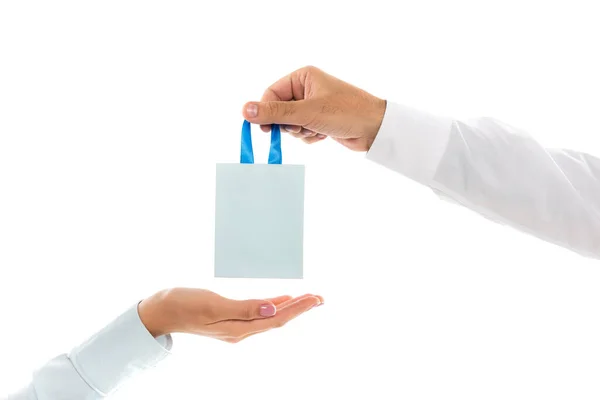 Vista recortada del hombre sosteniendo bolsa de papel cerca de la mano femenina aislada en blanco - foto de stock