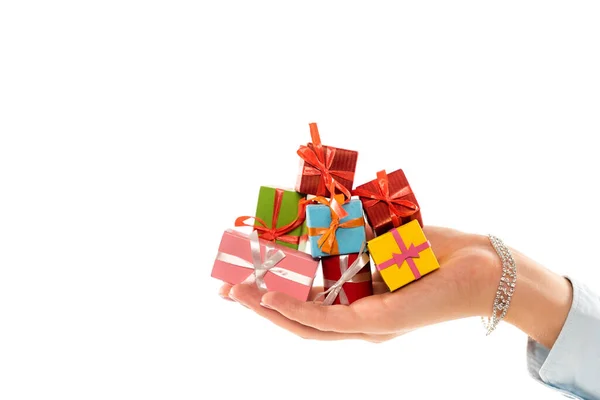 Vista recortada de la mujer sosteniendo caja de regalo colorida y diminuta aislada en blanco - foto de stock