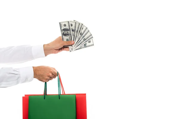 Cropped view of rich man holding dollar banknotes and shopping bags isolated on white — Stock Photo