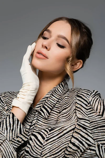 Pretty woman in blouse with animal print and white glove posing isolated on grey — Stock Photo