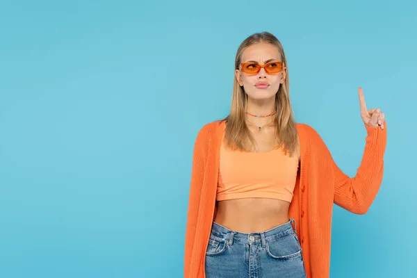 Pensive blonde woman in sunglasses having idea isolated on blue — Stock Photo