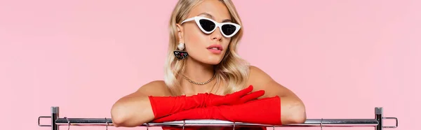 Элегантная блондинка в солнечных очках и красных перчатках позирует изолированно на розовом, баннер — стоковое фото