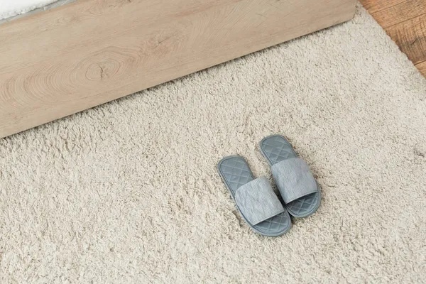 High angle view of grey slippers on beige carpet — Stock Photo