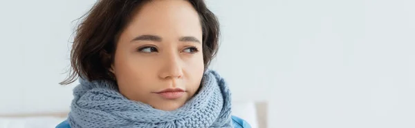 Mujer joven en bufanda de punto mirando hacia otro lado, bandera - foto de stock