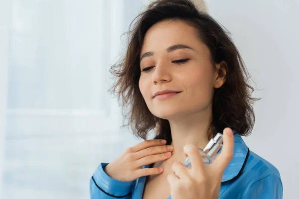 Agradou jovem mulher pulverizando perfume no pescoço — Fotografia de Stock