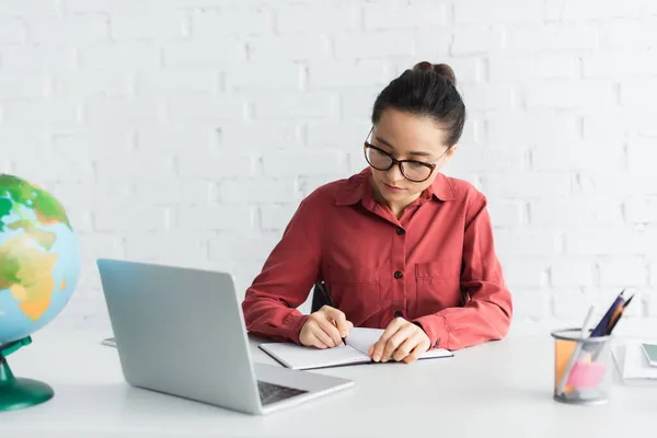 Junge Lehrerin mit Brille arbeitet von zu Hause aus — Stockfoto