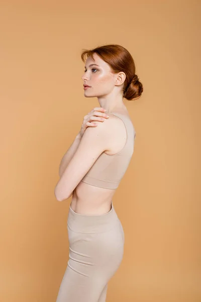 Pretty redhead woman looking away isolated on beige — Stock Photo
