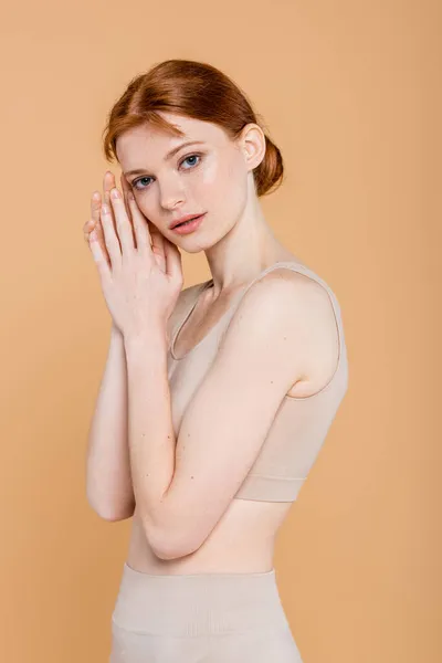 Bella donna dai capelli rossi con lentiggini guardando la fotocamera isolata sul beige — Foto stock