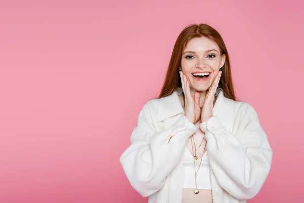 Aufgeregt rothaarige Frau in Jacke blickt in die Kamera isoliert auf rosa — Stockfoto