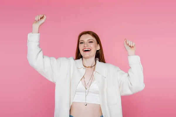 Femme rousse excitée regardant la caméra isolée sur rose — Photo de stock