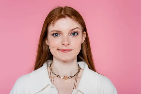 Pensiva donna dai capelli rossi guardando la fotocamera isolata su rosa — Foto stock