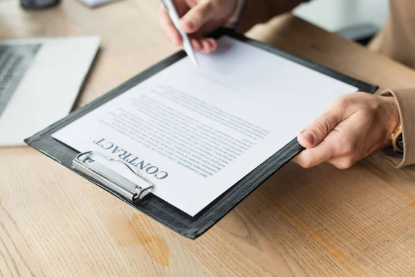 Partial view of blurred businessman signing contract in office, anti-corruption concept — Stock Photo