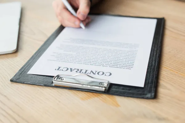 Partial view of businessman signing contract on clipboard, anti-corruption concept — Stock Photo