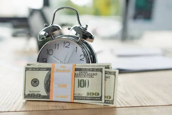 KYIV, UKRAINE - SEPTEMBER 22, 2021: pack of dollar banknotes near vintage alarm clock, anti-corruption concept — Stock Photo