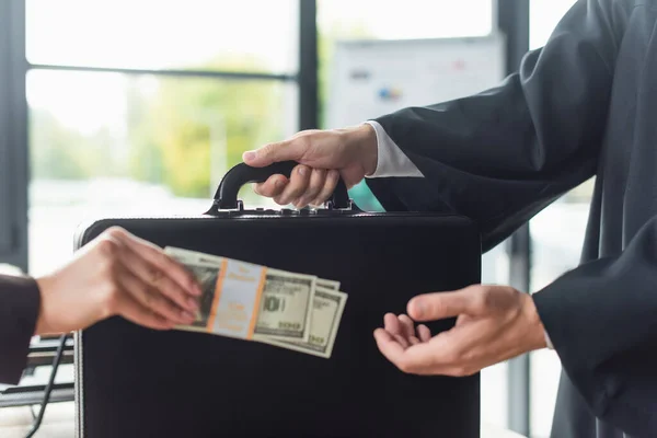 Cropped view of blurred woman with dollars near man with briefcase, anti-corruption concept — Stock Photo