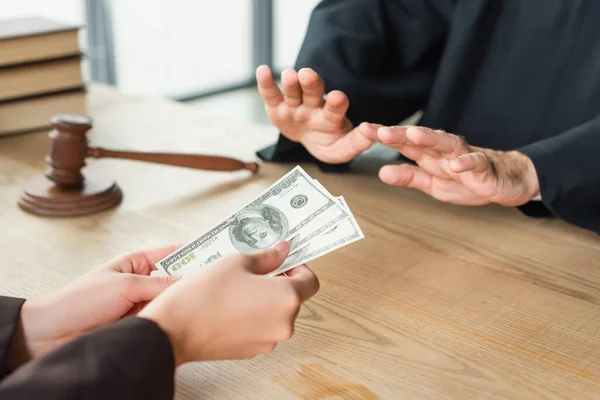Abgeschnittene Ansicht einer Frau, die Dollars in der Nähe eines Richters hält, zeigt Verweigerungsgeste, Antikorruptionskonzept — Stockfoto