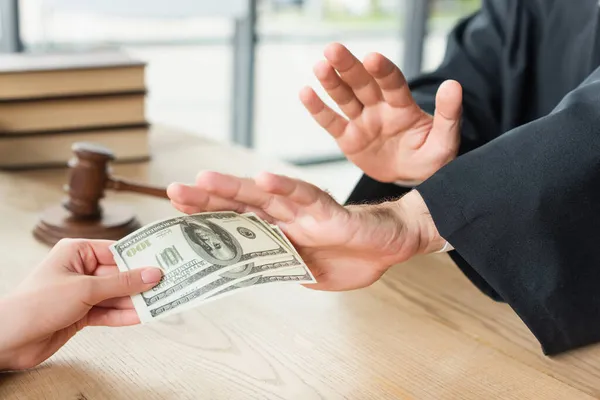 Partial view of judge showing stop gesture near client with dollars, anti-corruption concept — Stock Photo
