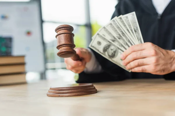 Cropped view of judge holding gavel and blurred dollars, anti-corruption concept — Stock Photo