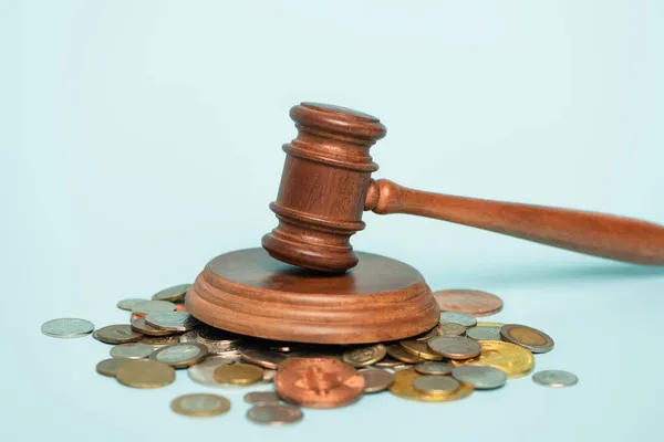 KYIV, UKRAINE - SEPTEMBER 22, 2021: wooden gavel near scattered coins on blue background, anti-corruption concept — Stock Photo