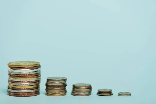 Stapel goldener und silberner Münzen auf blauem Hintergrund mit Kopierraum, Antikorruptionskonzept — Stockfoto