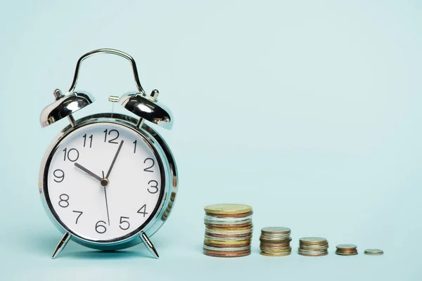 Vintage alarm clock near stacks of coins on blue background, anti-corruption concept — Stock Photo