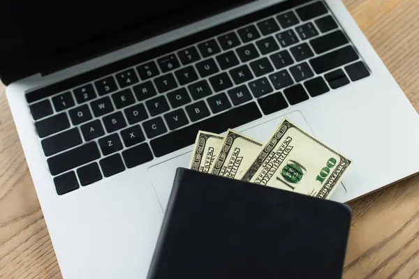 Top view of notebook with dollar banknotes on laptop with blank screen, anti-corruption concept — Stock Photo