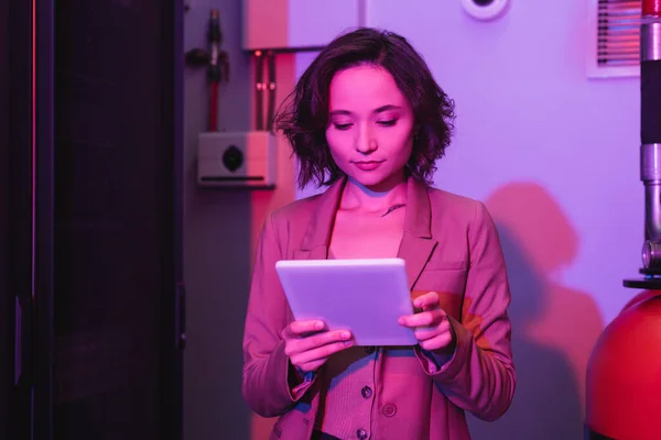 Молодая женщина с цифровым планшетом во время работы в дата-центре — стоковое фото