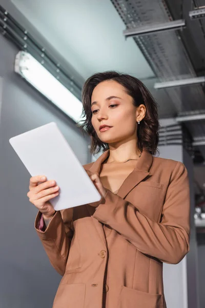 Low angle view of young programmer using digital tablet in data center — Stock Photo