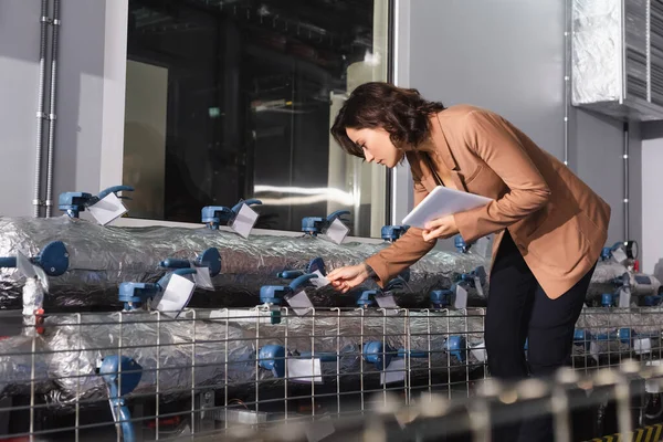 Ingeniero con tableta digital que comprueba el sistema de refrigeración del centro de datos - foto de stock