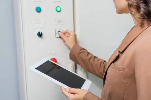 Vista ritagliata di ingegnere che tiene tablet digitale con schermo vuoto mentre preme il pulsante sul centralino nel data center — Foto stock