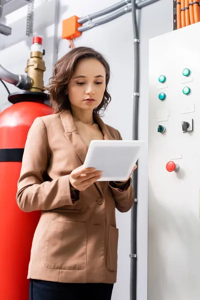 Engineer using digital tablet near switchboard in data center — Stock Photo
