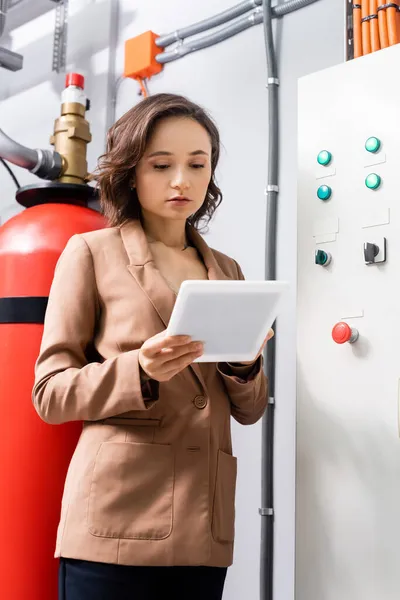 Ingeniero que utiliza la tableta digital cerca de centralita en centro de datos - foto de stock