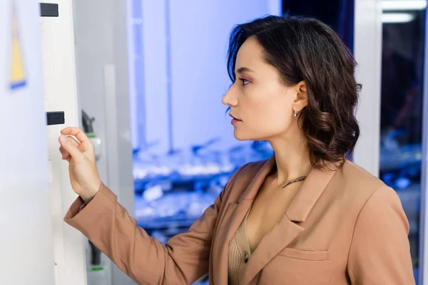 Seitenansicht eines Ingenieurs, der in der Nähe eines Schaltschranks im Rechenzentrum steht — Stockfoto