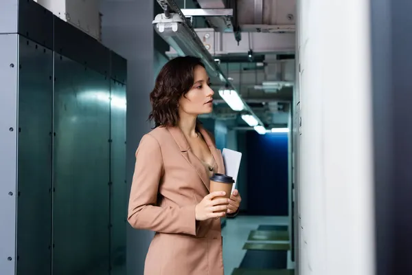 Mulher com tablet digital e café para ir olhando para o servidor no data center — Fotografia de Stock