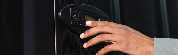 Cropped view of african american engineer touching control panel on server, banner — Stock Photo