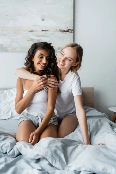 Freudige lesbische Frauen, die sich im Schlafzimmer umarmen — Stockfoto