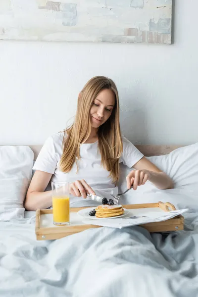 Mulher satisfeita tomando café da manhã na cama — Fotografia de Stock