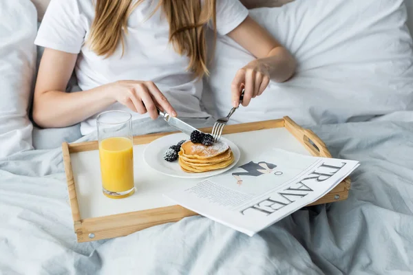 Abgeschnittene Ansicht einer jungen Frau beim Frühstück im Bett — Stockfoto